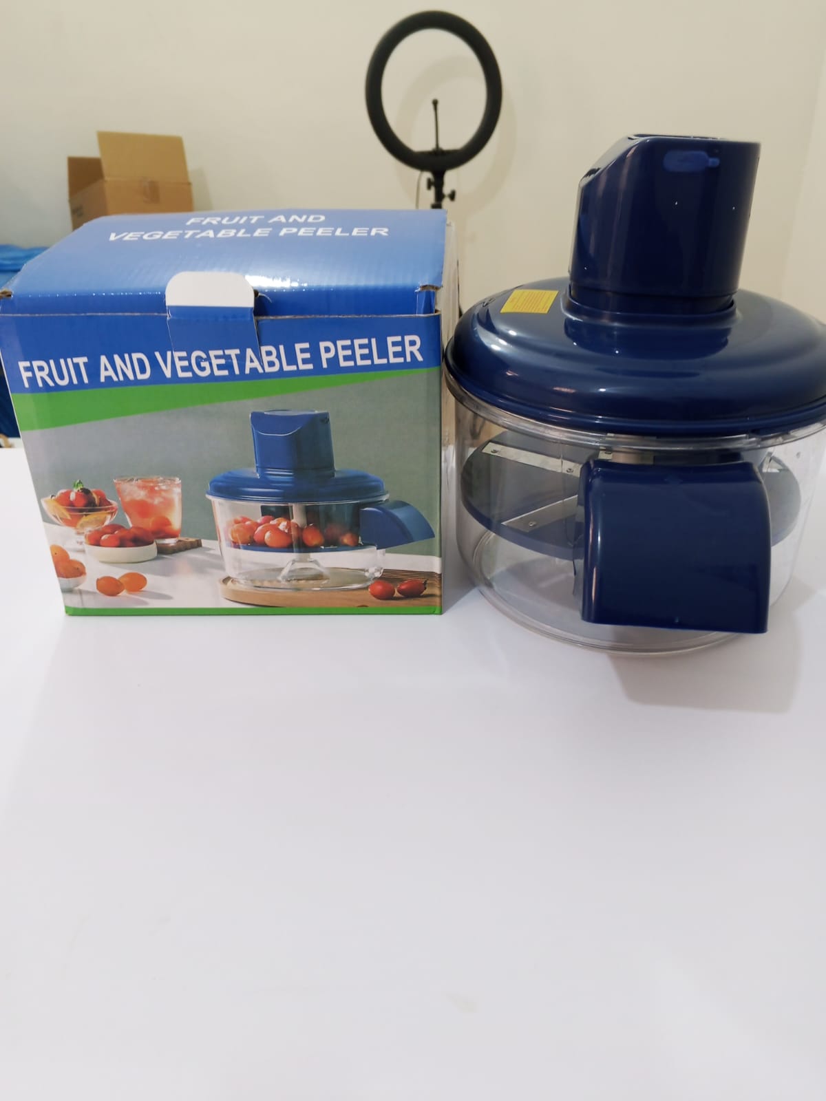 Automatic chargeable vegetable peeler by My Store, showing a sleek electric peeler with peeled fruits and vegetables on a countertop.